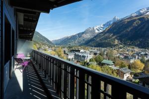een balkon met uitzicht op de stad en de bergen bij Residence du Brevent in Chamonix-Mont-Blanc