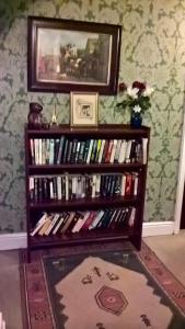 una estantería llena de libros en una habitación en Rhymney House hotel, en Caerphilly