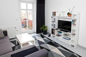 sala de estar con sofá y TV en Altstadt-Domizil 7, en Leer