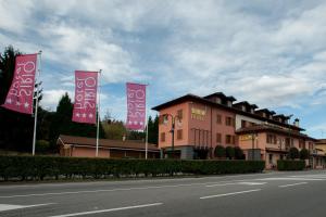 ein Gebäude mit rosa Bannern an der Seite einer Straße in der Unterkunft SIRIOHotel in Dormelletto