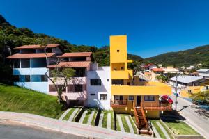 a yellow and white house on a hill at Vila Artesania in Bombinhas