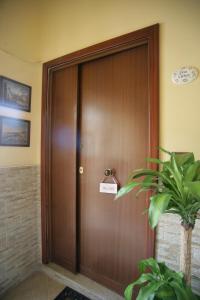 una puerta del ascensor de madera con un cartel en Casa Carmen, en Nápoles
