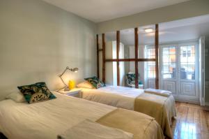 リスボンにあるAngel's Duplex Terrace Five Bedroomsのベッドルーム1室(ベッド2台、窓付)
