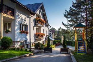 a house with a gazebo and chairs on a street at Guest house Vila Žunić in Zlatibor