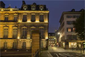 un antiguo edificio en una calle de la ciudad por la noche en L'oeil sur la flèche, en Estrasburgo