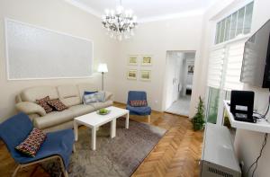 City Center Apartment MIKA في بلغراد: غرفة معيشة مع أريكة وطاولة