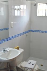 un bagno bianco con lavandino e WC di Hotel Joohn Gay only LGBTIQ a Melgar