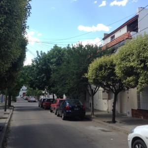 a street with cars parked on the side of the road at La Casa Roja Arroyito Rio in Rosario