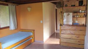 a bedroom with a bed and a refrigerator at Cabañas Peñi Huen in Lago Puelo