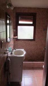 baño con lavabo, bañera y ventana en Cabañas Peñi Huen en Lago Puelo