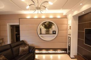 un soggiorno con divano e specchio di H & V Residence - Bungalow Apartment a Arad