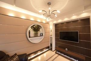 un soggiorno con TV e specchio di H & V Residence - Bungalow Apartment a Arad