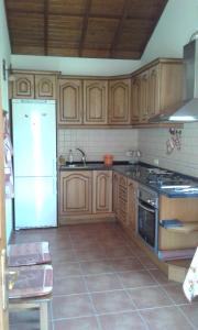 a kitchen with wooden cabinets and a white refrigerator at Casa Rural Rincón del Olivo in Lomito Fragoso y Honduras