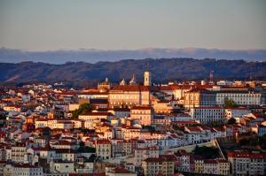 um horizonte da cidade com edifícios e montanhas ao fundo em Confluentia H&A - Believe It or Not Apartments em Coimbra