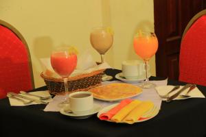 einen Tisch mit zwei Weingläsern und Essen darauf in der Unterkunft Keba Guest House in Addis Abeba