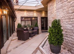 un patio con sedie e alberi di fronte a un edificio di H & V Residence - Bungalow Apartment a Arad