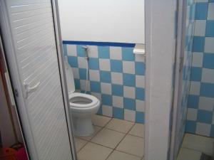 y baño con aseo y azulejos azules y blancos. en Le Yanrie, en Bouchon