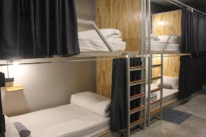 a room with three bunk beds in a room at Ekanek Hostel in Bangkok