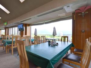 a dining room with a green table and chairs at Cocopa Resort Club in Tsu