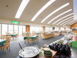 a dining room with tables and chairs and a cafeteria at Cocopa Resort Club in Tsu