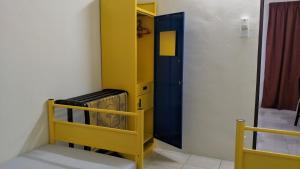 Zimmer mit gelbem Regal und gelber Tür in der Unterkunft Airis Homestay Changlun in Changlun