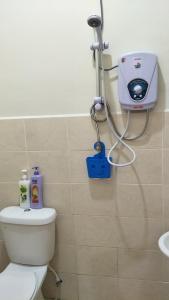 a bathroom with a toilet and a blow dryer on the wall at Airis Homestay Changlun in Changlun