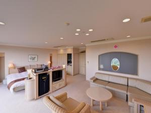 a large living room with a bed and a television at Cocopa Resort Club in Tsu