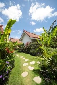 einen Garten mit Steppsteine im Gras in der Unterkunft Bingin Bienvenue Guest House in Uluwatu