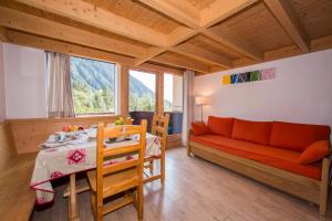 ein Wohnzimmer mit einem roten Sofa und einem Tisch in der Unterkunft Résidence Grand Roc - Bruyères 116 - Happy Rentals in Chamonix-Mont-Blanc