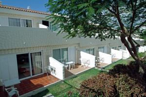 een huis met witte stoelen en een patio bij Paradero II in Playa de las Americas