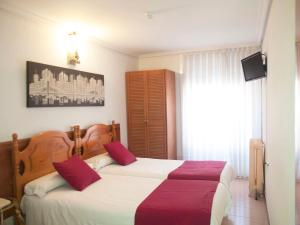 a bedroom with two beds with red pillows at Dato 2 in Vitoria-Gasteiz