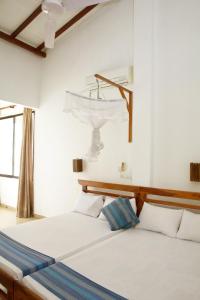 two beds in a room with white walls and a window at Beach Inns Holiday Resort in Matara