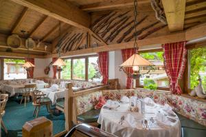 een restaurant met banken, tafels en ramen bij Das Rotspitz Adults - only in Maurach