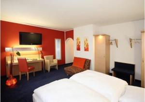 Cette chambre comprend deux lits et un bureau. dans l'établissement Hotel Silberhorn, à Nuremberg
