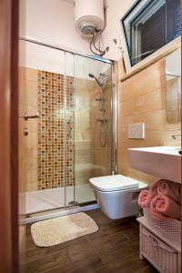 a bathroom with a shower and a toilet and a sink at Apartments & Rooms Chiara in Rovinj