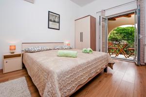 a bedroom with a large bed and a balcony at Apartments & Rooms Chiara in Rovinj