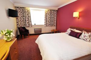 a hotel room with a bed and a tv at Supreme Inns Boston in Swineshead