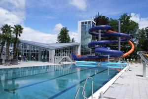 a swimming pool with a water slide in front of a building at Drevenica pod Tlstou in Blatnica
