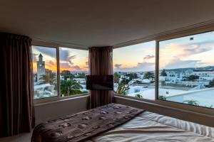 a bedroom with a bed and a large window at Maison d'Hôtes Dar Ennassim in La Marsa