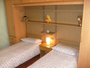 オッジェッビオにあるCasa Coccinellaの小さなベッドルーム(ツインベッド2台、ランプ付)