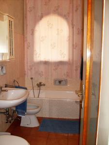 een badkamer met een bad, een toilet en een wastafel bij Casa Coccinella in Oggebbio