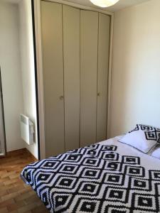 卡诺海滩Exceptionnel ! Appartement vue imprenable sur mer.的一间卧室配有一张带黑白棉被的床