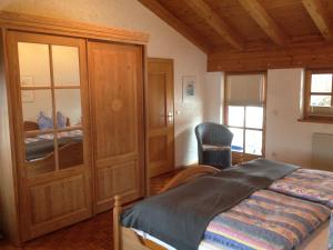 1 dormitorio con 1 cama y 1 silla en una habitación en Ferienwohnung Weinberger, en Regen