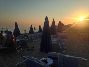 パラジャーノにあるA Casa di Mariaのビーチでの夕暮れ時のパラソルと椅子
