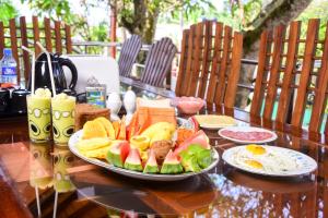 a wooden table with a plate of food on it at Channa Villa & Tours in Bentota