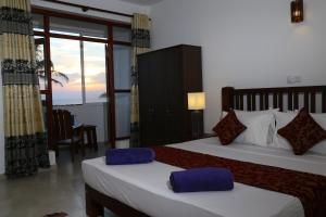 Uma cama ou camas num quarto em Hikka Regent Hotel