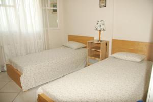 a bedroom with two beds and a lamp on a night stand at Villa Vlichos in Amarynthos