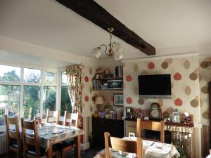 a dining room with a table and a tv at Hillside Bed and Breakfast in Bedale