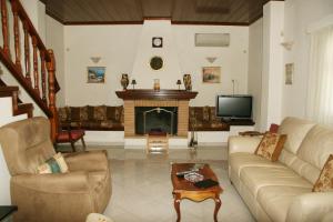 a living room with a couch and a fireplace at Villa Vlichos in Amarynthos +22 photos