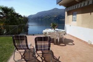 a table and chairs on a patio with a view of a lake at Casa Riva in Poggio